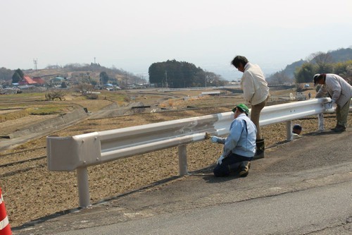 中野区の道路沿いのガードレールを景観配慮色（グレーベージュ）に塗り替えている様子