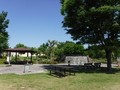 甲西ふれあい公園内の奥に池、手前に大きな木とベンチなどの憩いの場の写真